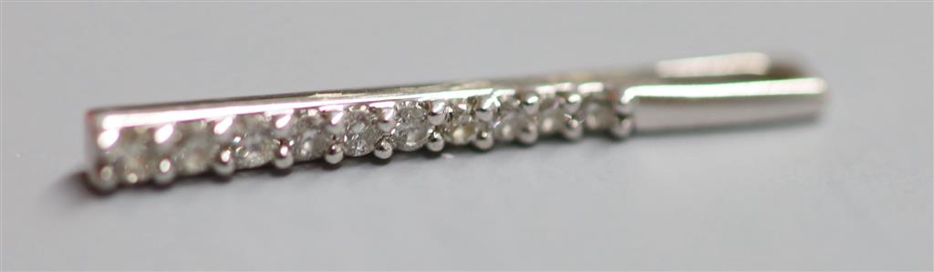 A modern 9ct white gold and ten stone diamond chip set line pendant,24mm, gross 0.6 grams.